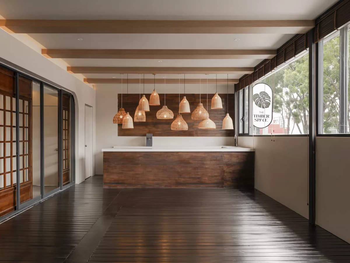 a wooden counter, hanging lights, and large windows overlooking a green view