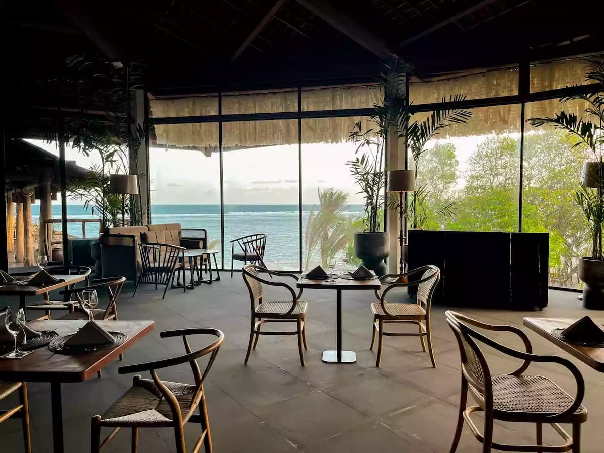 dining space with rattan chairs facing ocean view