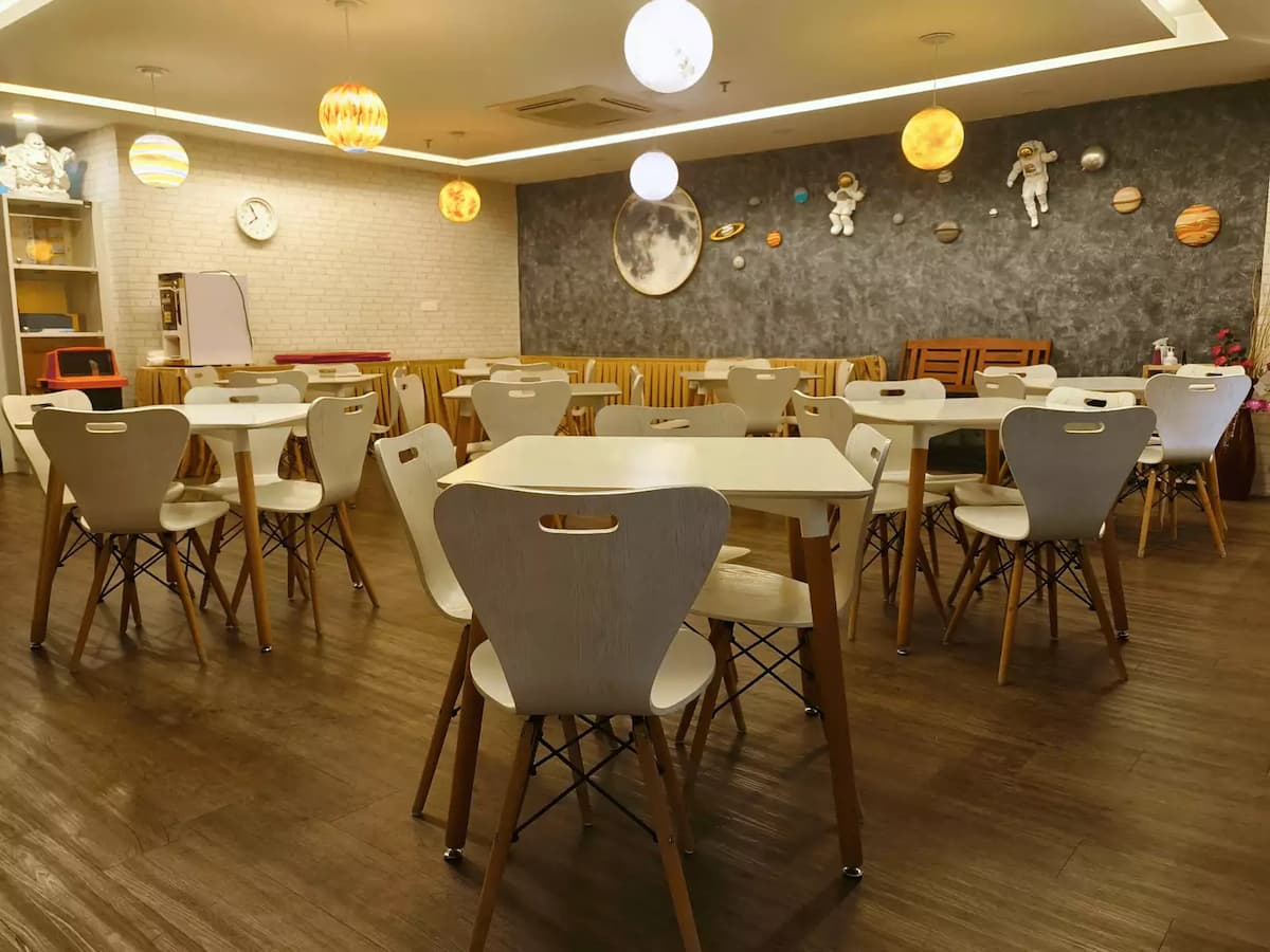 white tables and chairs, planetary wall decorations, astronaut figurines