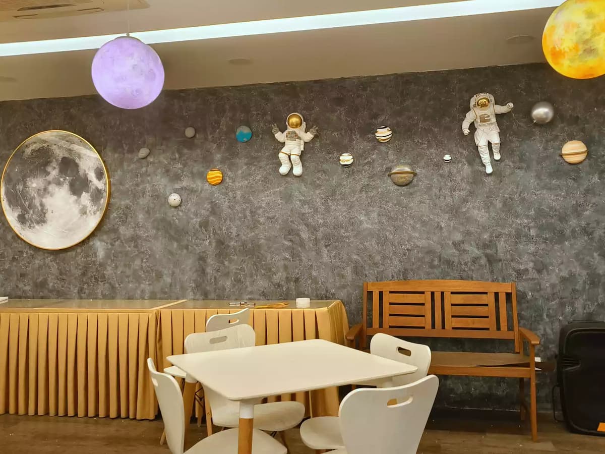 space-themed event hall featuring a cosmic wall design with astronaut and planet decorations