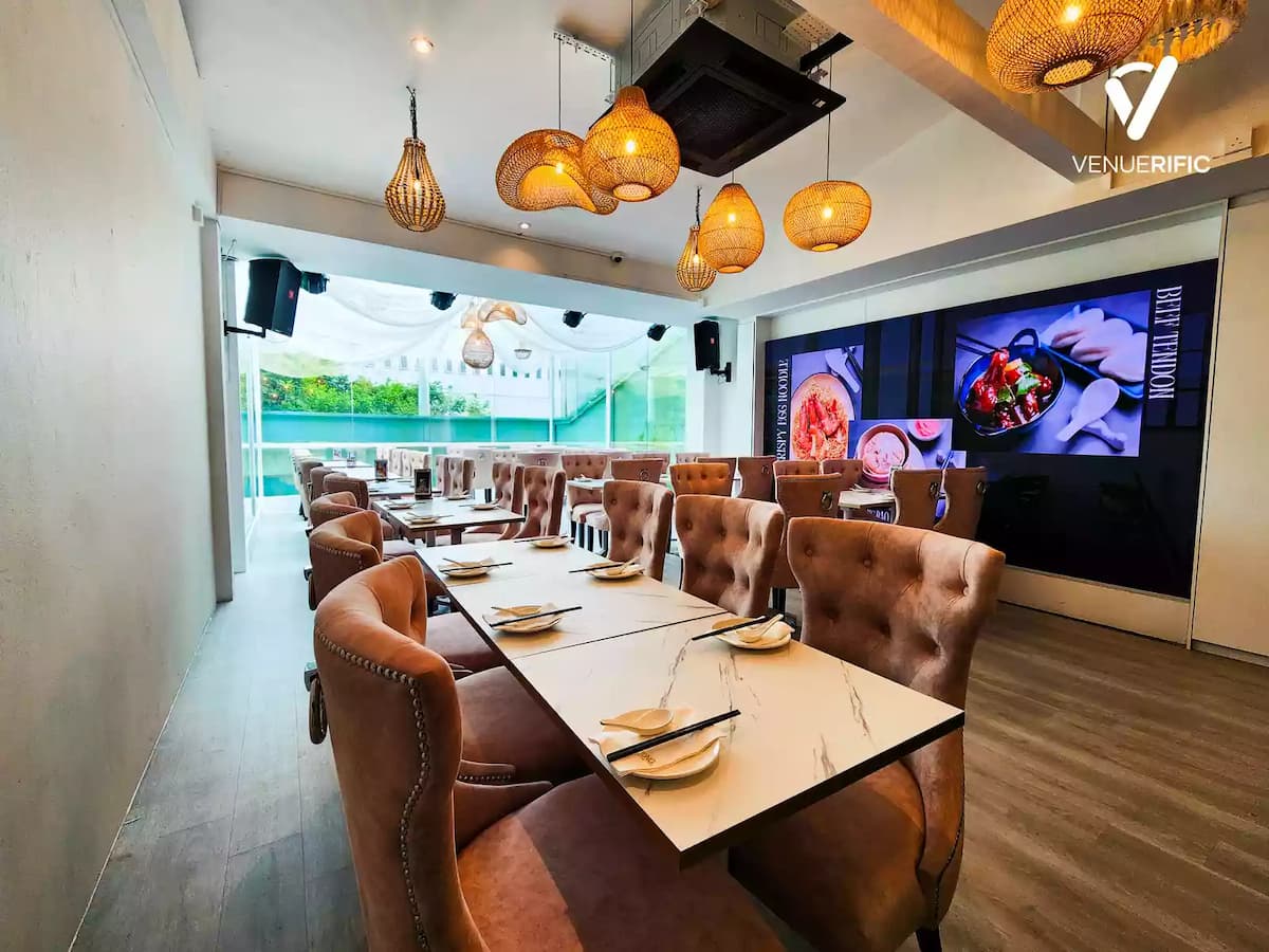 Elegant dining venue with tufted blush chairs, marble-top tables, woven pendant lights, and a large LED display wall.