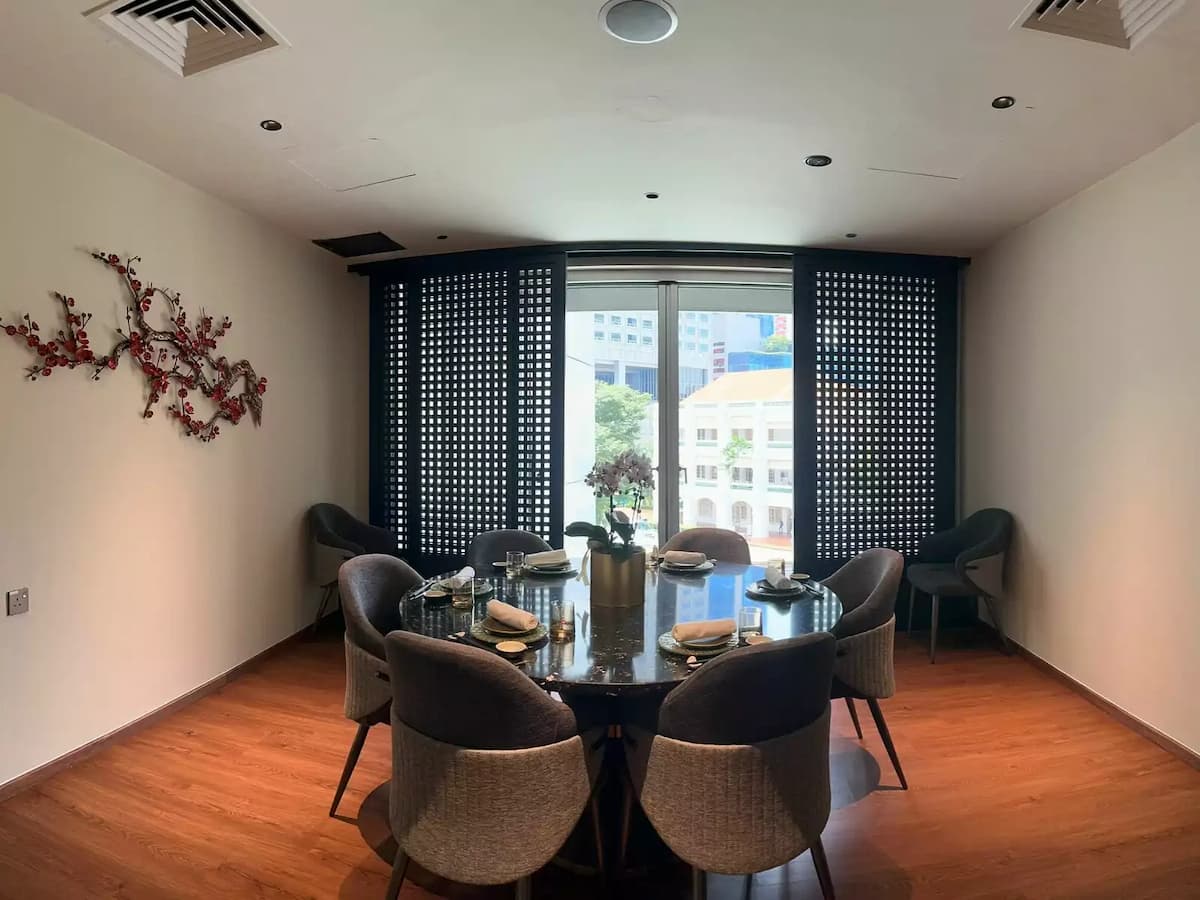 An elegant private dining room featuring a round black marble table set for six
