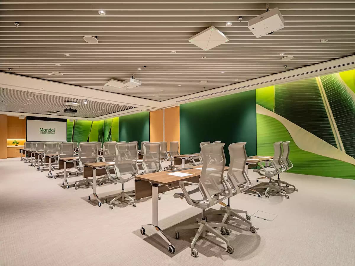 Modern training room with flexible tables, ergonomic chairs, and nature-themed walls.