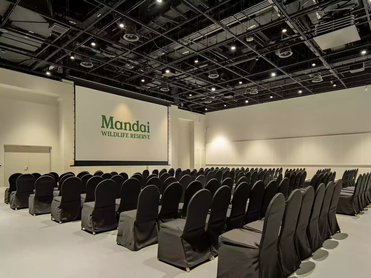 Spacious event hall with theatre seating and large projection screen.