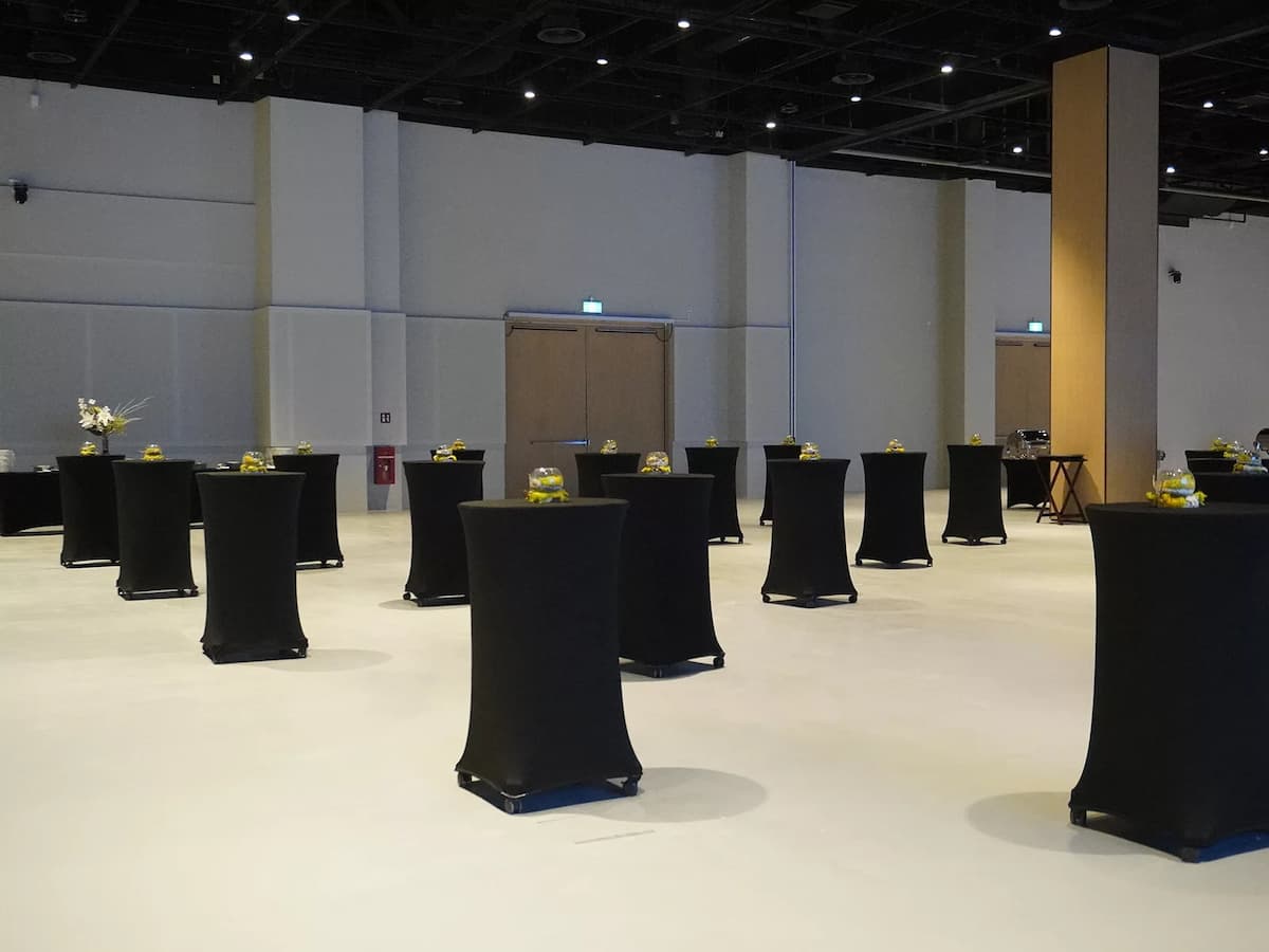 Large event hall arranged for cocktail reception with high tables.