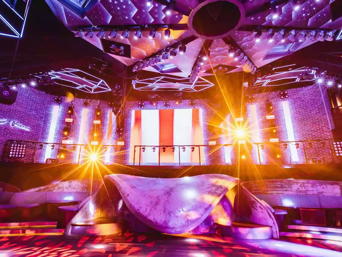 Immersive nightclub interior with dramatic LED lighting, multi-level stage, and vibrant neon accents.