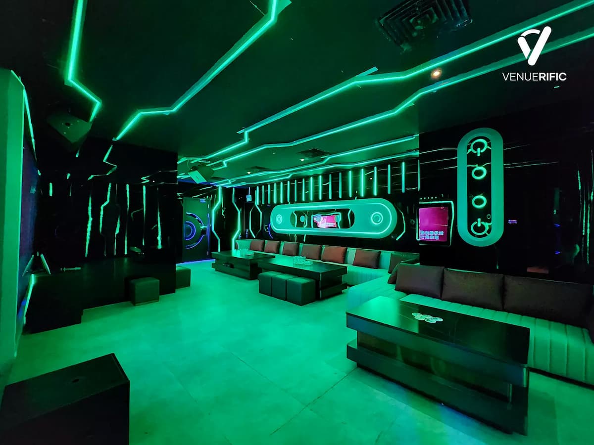 Red-lit futuristic VIP lounge with white sectional sofas and red pillows.