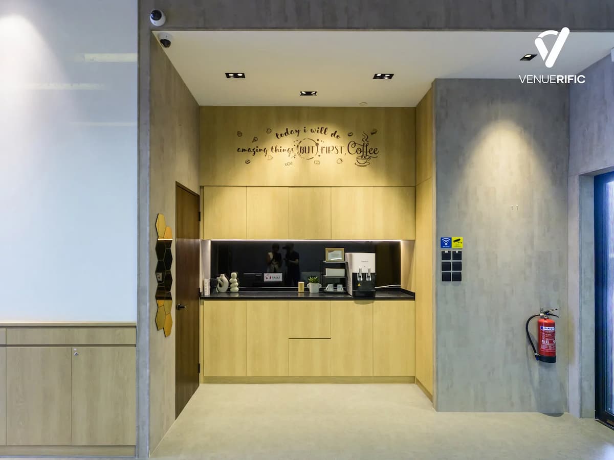 Minimalist coffee counter with light wood cabinetry, concrete walls, and a clean, modern design.