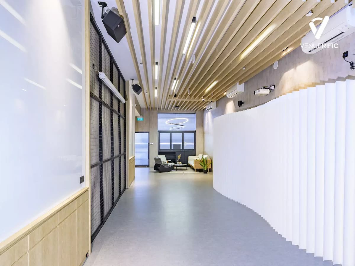 Bright modern corridor with wood slat ceiling, minimalist walls, and an open, gallery-style layout.