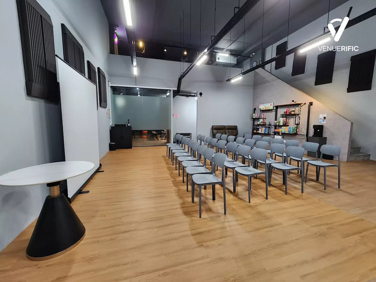 Classroom-style event setup with rows of chairs, presentation area, and an open industrial interior.