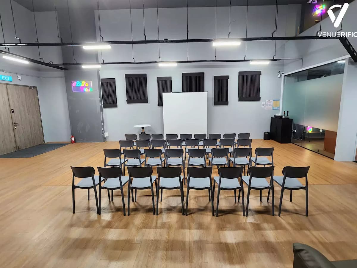 Classroom-style event room with rows of chairs facing a screen in a clean, modern space.