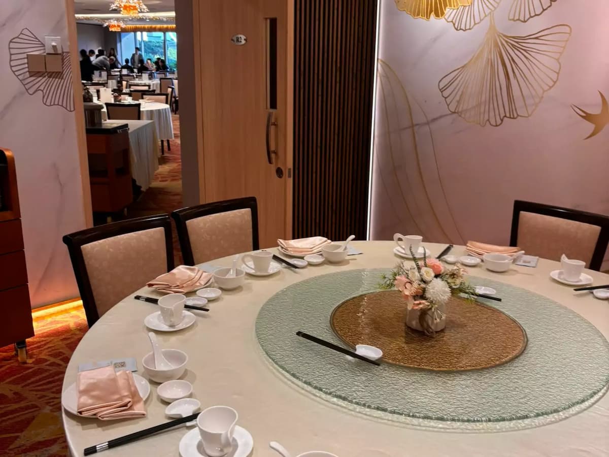 Intimate private dining table with elegant place settings, floral centerpiece, and warm, refined interior details.