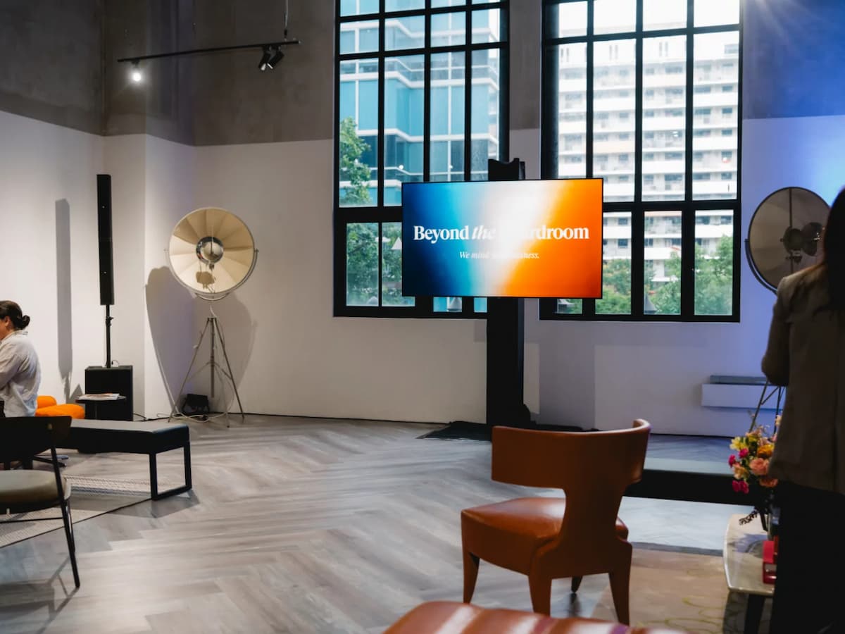 Event lounge setup with presentation screen and modern seating.