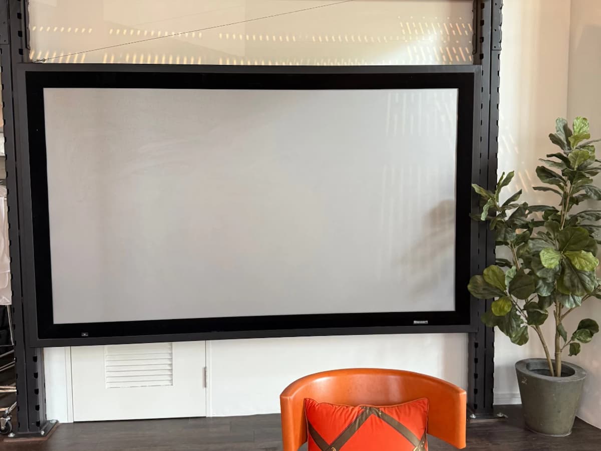 Large presentation screen in modern event or lounge space.”
