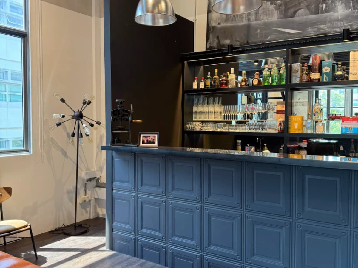 Modern bar counter with liquor shelves and industrial décor.