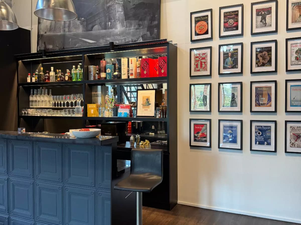 Bar area with liquor display and framed magazine covers on wall.