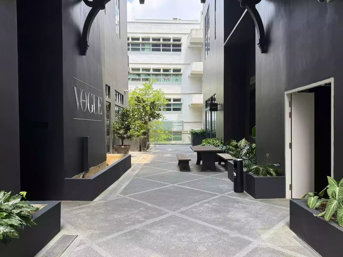 Outdoor courtyard with seating, greenery, and modern architecture.