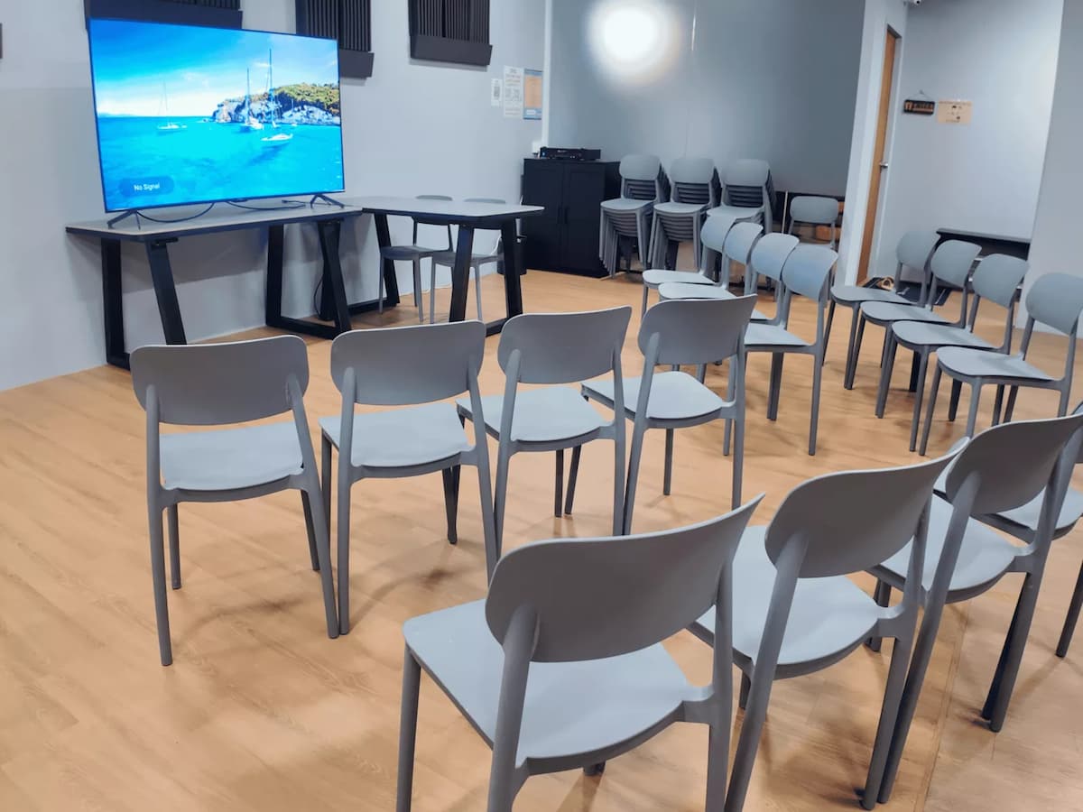Simple classroom-style setup with rows of chairs facing a screen, suitable for talks or presentations.