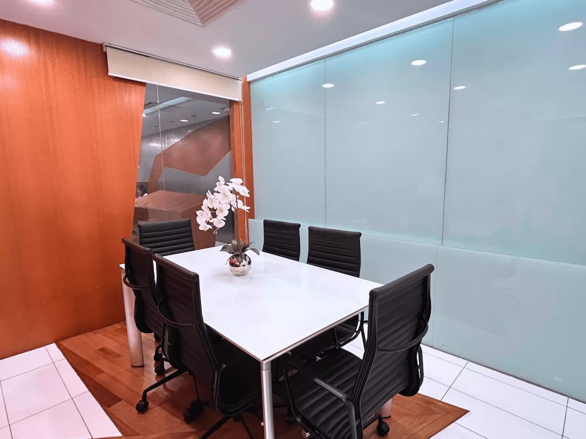 Compact meeting room with white table and black chairs