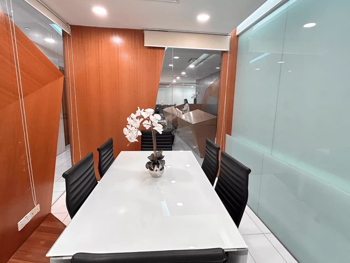 Clean and neat meeting room with white table and black chairs