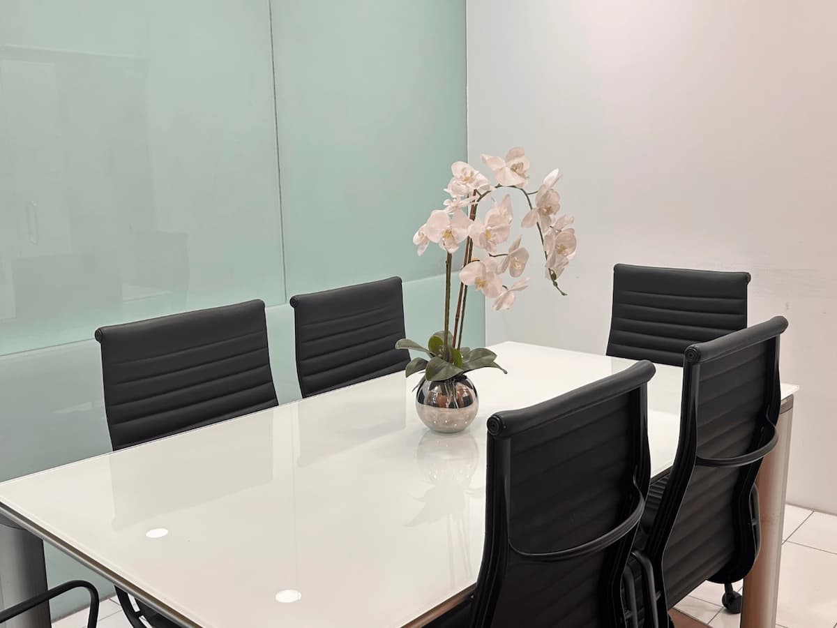 Minimalist meeting room with white table and black chairs