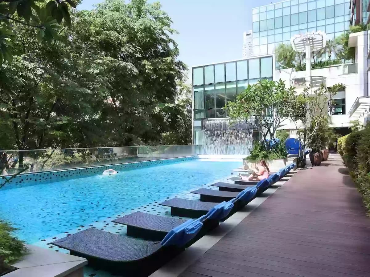 Outdoor pool area at Park Regis with sun loungers and greenery.
