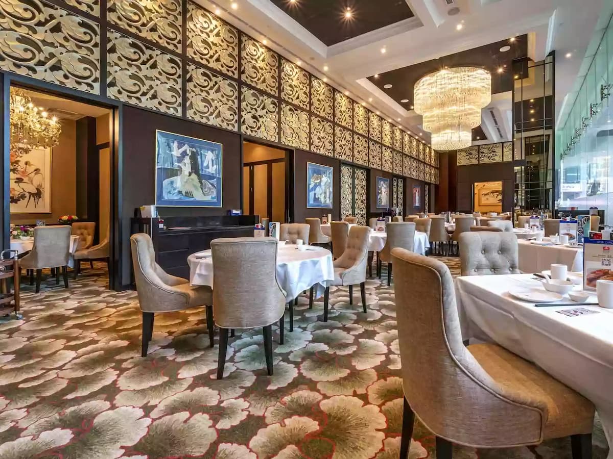 Elegant dining area with chandelier and patterned wall panels.