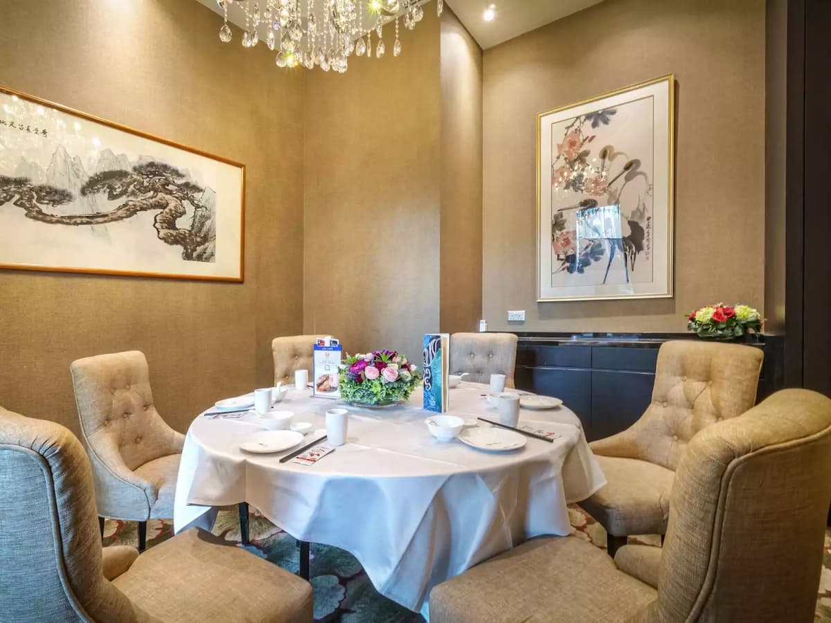 Private dining room with round table and upholstered chairs.
