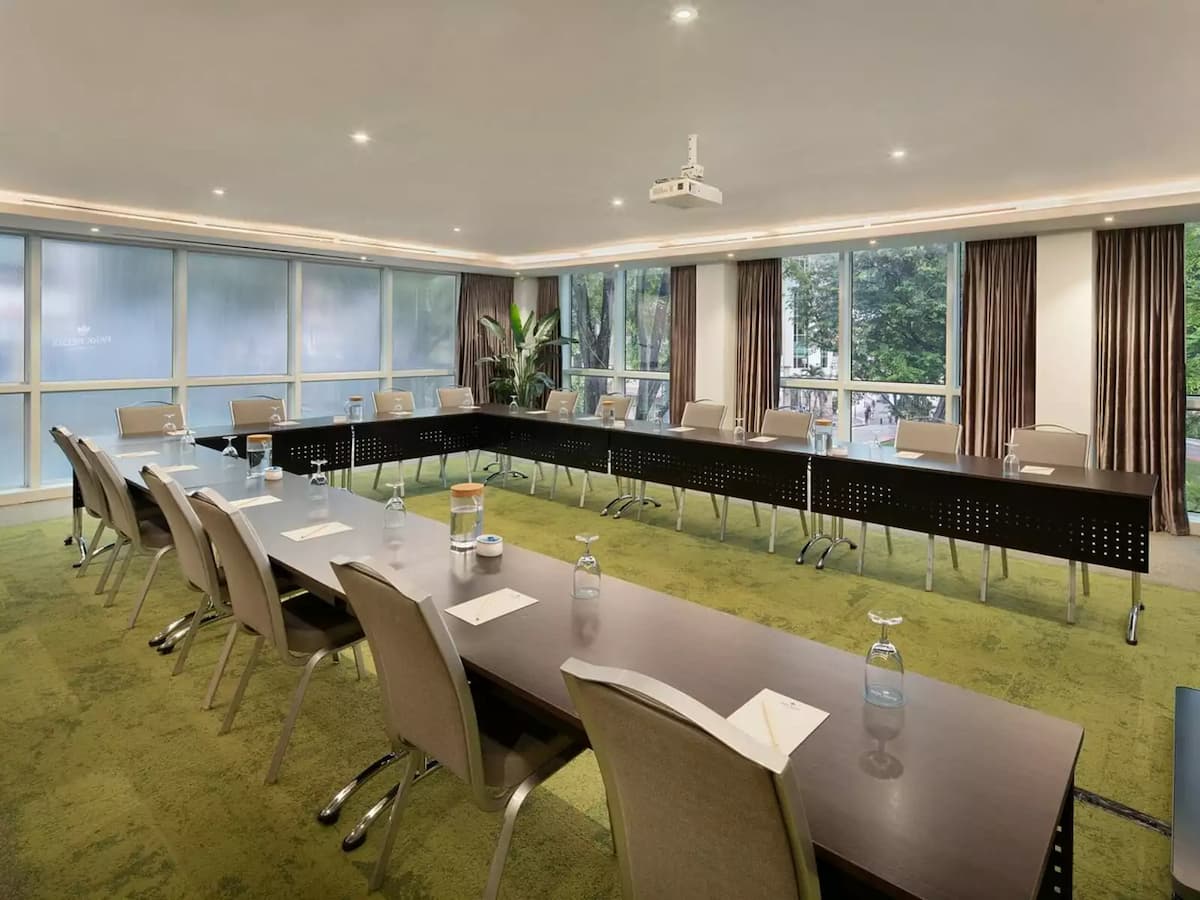 Conference room with U-shaped table setup and natural daylight.