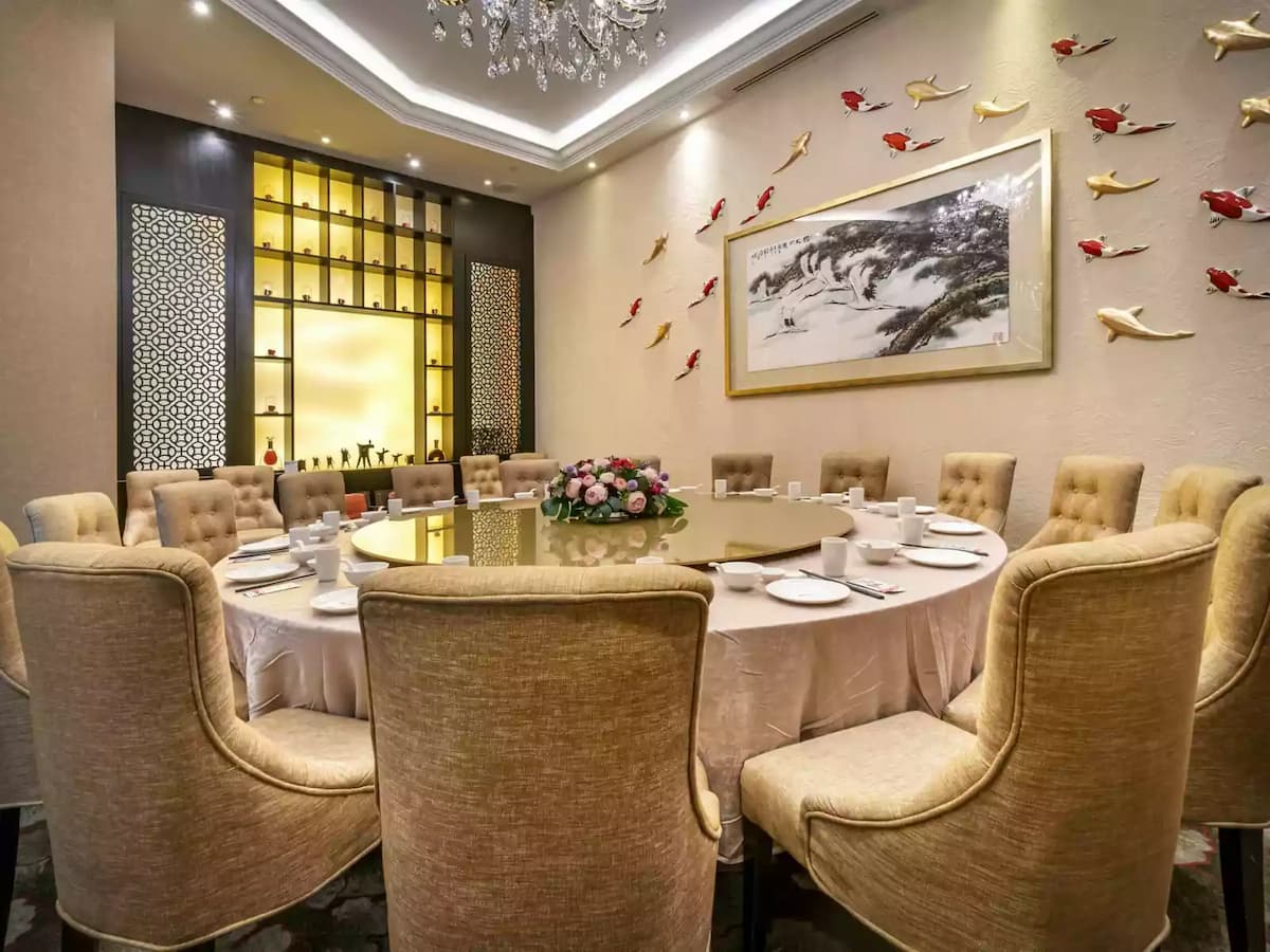 Private dining room with round table, chandelier, and elegant décor.