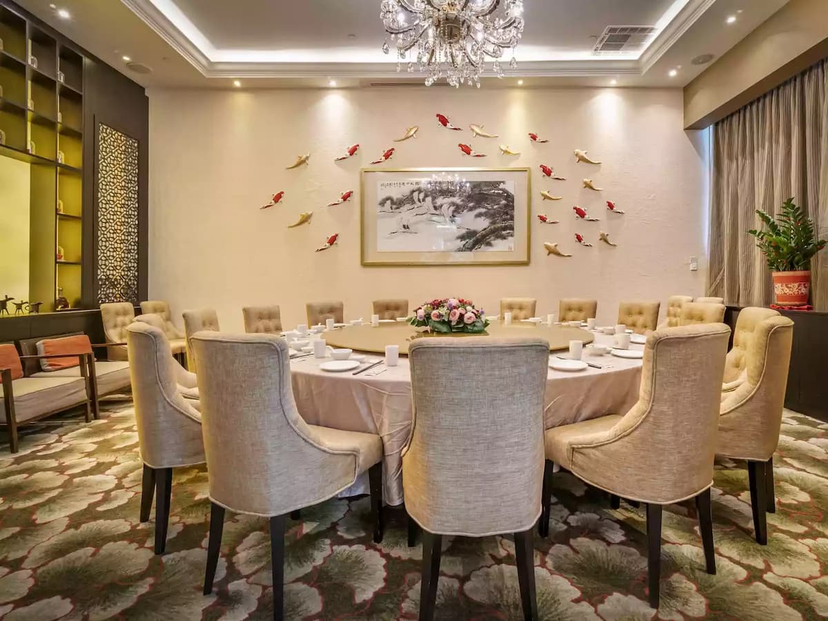 Elegant private dining room with round table and chandelier.