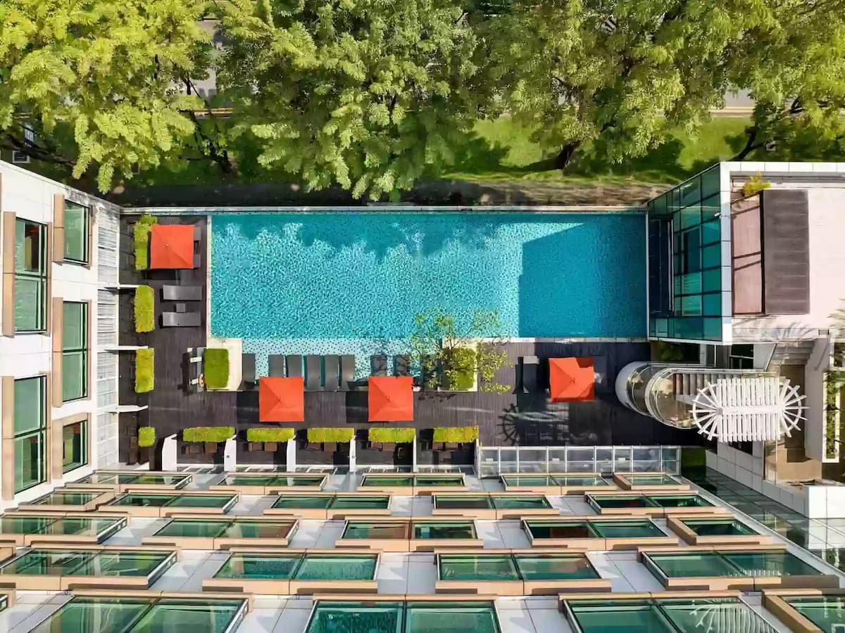 Aerial view of infinity pool with sun loungers and umbrellas.