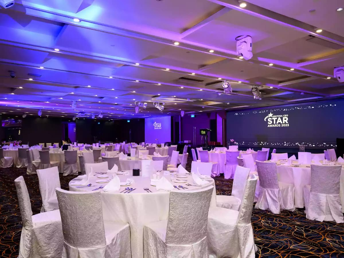 Corporate awards banquet with round tables and stage lighting.