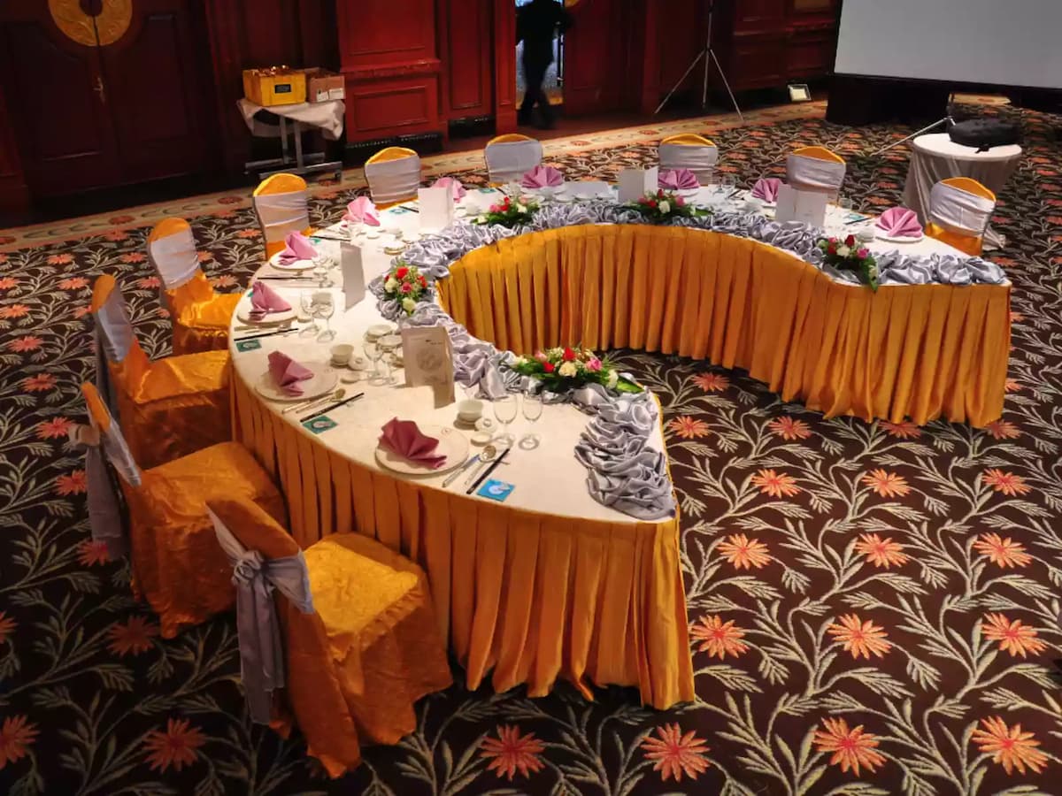 Curved banquet table arrangement with elegant table settings and floral décor—ideal for wedding receptions, VIP dining setups, corporate banquets, and formal celebration events.
