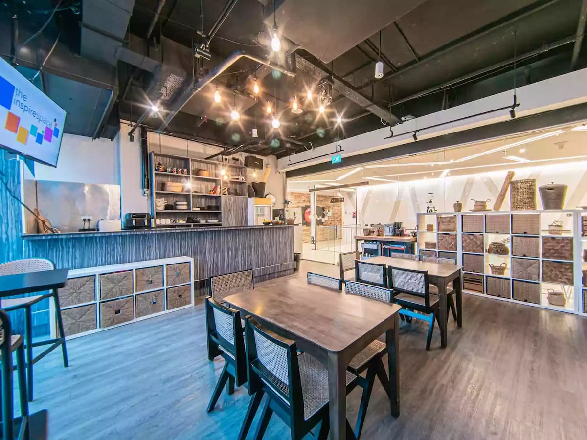 Contemporary workshop and event space with flexible table seating, large windows, and presentation screens—ideal for meetings, workshops, networking sessions, and small corporate events.