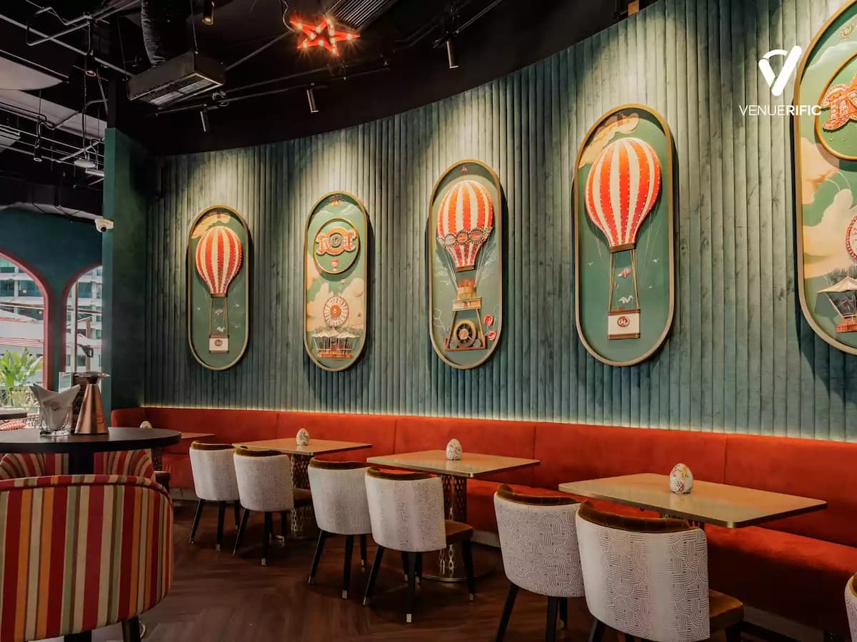 Cozy dining area with upholstered seating, hot air balloon wall art, and warm ambient lighting for relaxed meals.