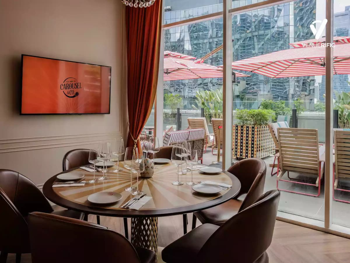 Private dining room with a round table, elegant place settings, and floor-to-ceiling windows overlooking an outdoor terrace.
